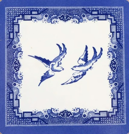 Two flying blue birds surrounded by patterned border.